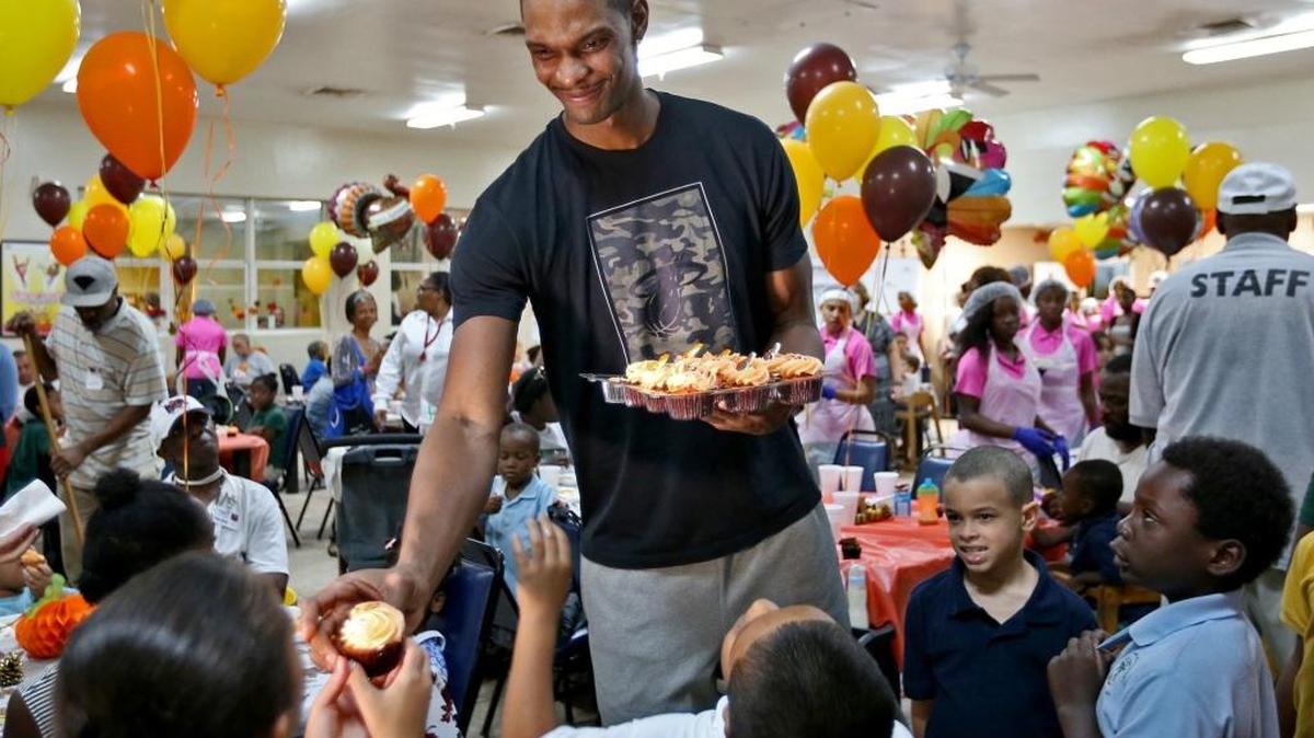 Miami Heat star Chris Bosh has a cupcake and a smile for a child at the Chapman Partnership on Wednesday, Nov. 18, 2015. Chris and his wife, Adrienne Bosh, returned to Chapman Partnership for the fourth year in a row to serve a pre-Thanksgiving dinner and celebrate the holidays with the homeless of Miami.