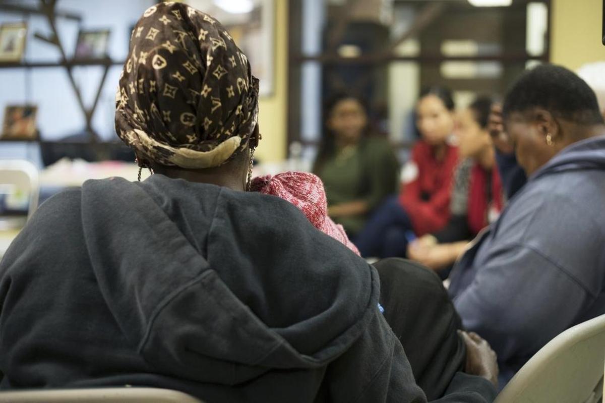 A mother hugs her 8-year-old daughter as she listens to testimonies of sexual abuse by other participants of the Women’s Circle at the Miami Workers Center.