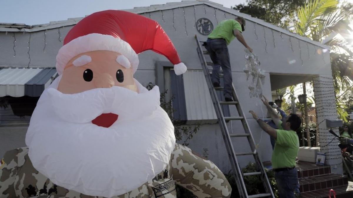 FPL volunteers install lights on the house of retired Marine Corp. Lt. Colonel Patrick McMullan on Tuesday, Dec. 5, 2017.