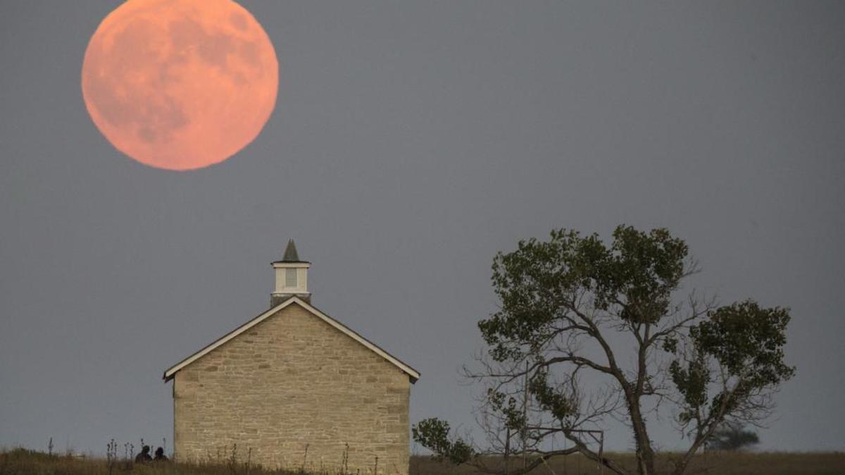 
A super moon rises over the Lower Fox Creek School near Strong City, Kan., Sunday, Sept. 27, 2015. It was the first time Sunday since 1982 that a total lunar eclipse was combined with a supermoon. 
