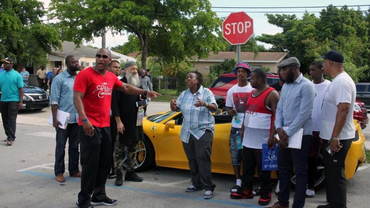 Community activist Renita Holmes, center, tells Liberty City locals that the feeling of driving a new Ferarri is nothing compared to graduating from college.