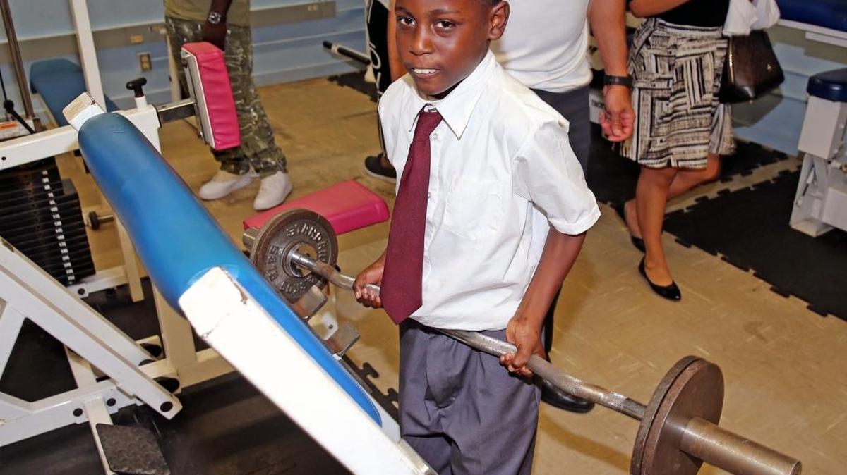 Sammuel Merius 7, uses a weight set at a new fitness center after a ribbon cutting in Brownsville, Aug. 29, 2017.