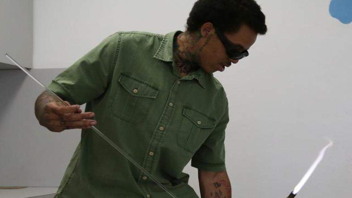 
Larry Whittaker, 22, pulls a long glass rod from his bag in preparation for a class he is about to teach. For two weeks, Whittaker, 22, demonstrated the art of glassblowing to children at the NFL Youth Education Town in Gwen Cherry Park near Liberty City. Communities in Schools of Miami, a nonprofit organization, hired Whittaker through a $6,000 grant they were awarded from the Miami-Dade County Department of Cultural Affairs.
