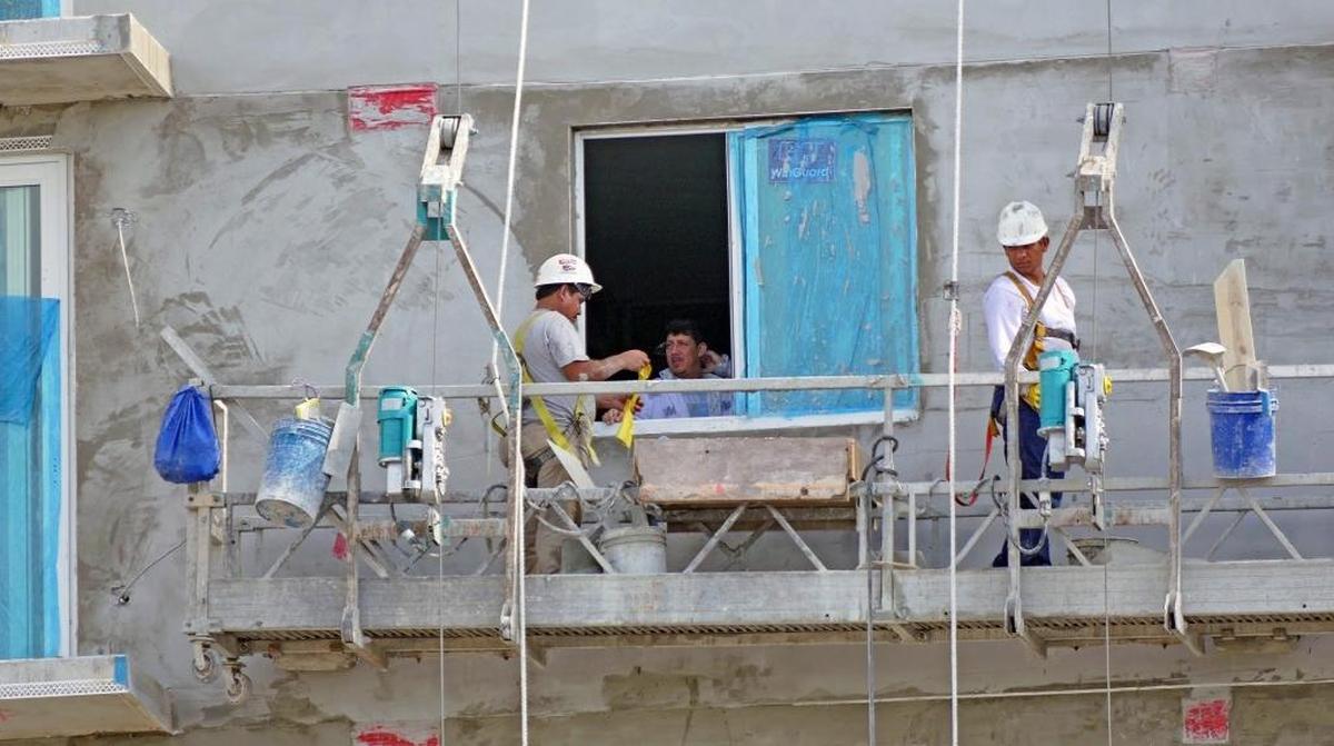 Plasterers high on a scaffold build affordable housing in Liberty City for struggling veterans on Thursday, July 27, 2017. Thanks to a $400,000 grant from The Home Depot Foundation's Veterans Housing grant program, the housing will open later this year.