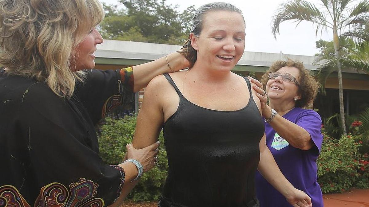 Appearing joyful, Stephanie Bagen, 33, center, stands after her baptism by Chaplain Laura Dahne, left, and Chaplain Cary Navarro on Thursday, March 24, 2016 at Agape in Southwest Miami-Dade County. Agape is a non-denominational, faith-based residential center that treats women dealing with substance abuse or other challenges. On Thursday afternoon, 11 women went to the baptismal font at Agape, near Goulds.