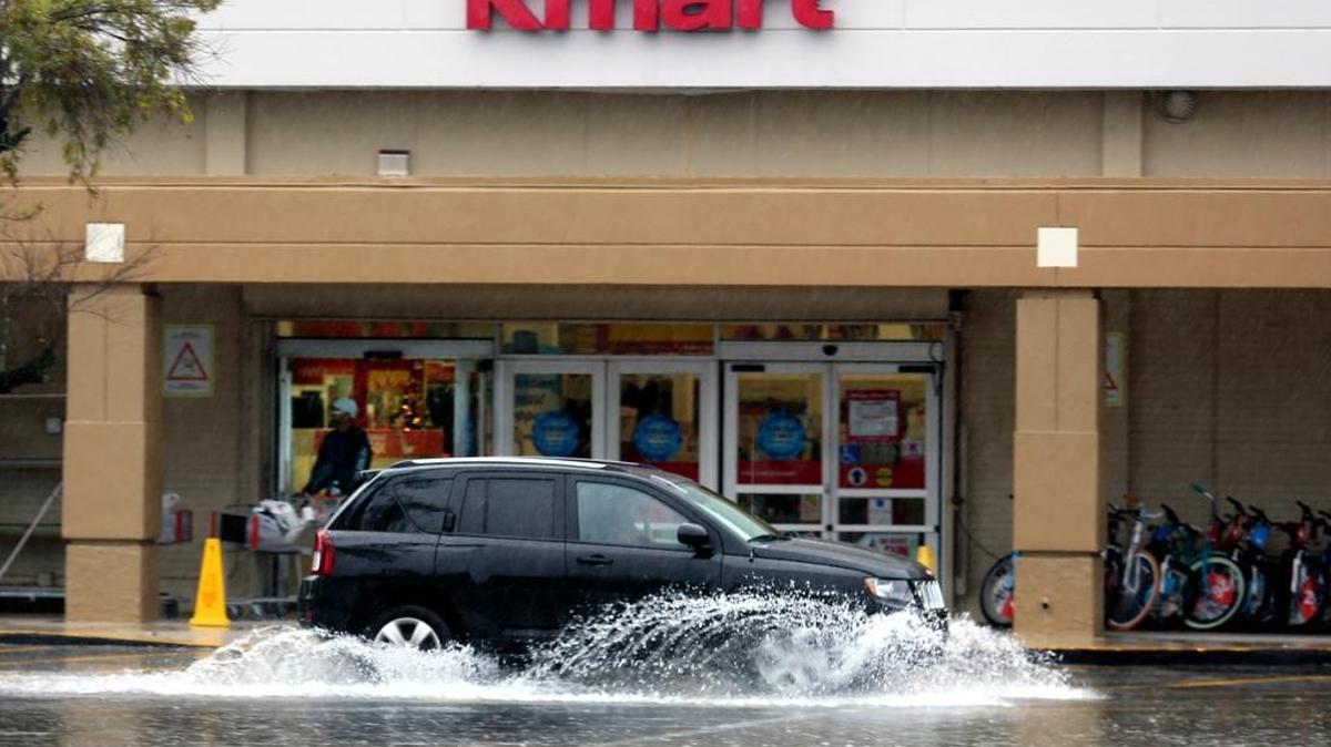 An SUV sends up a fan of water as splashes past the Kmart at 10700 Biscayne Blvd. on Friday morning, Dec. 4, 2015. The National Weather Service says December among third wettest since 1905.