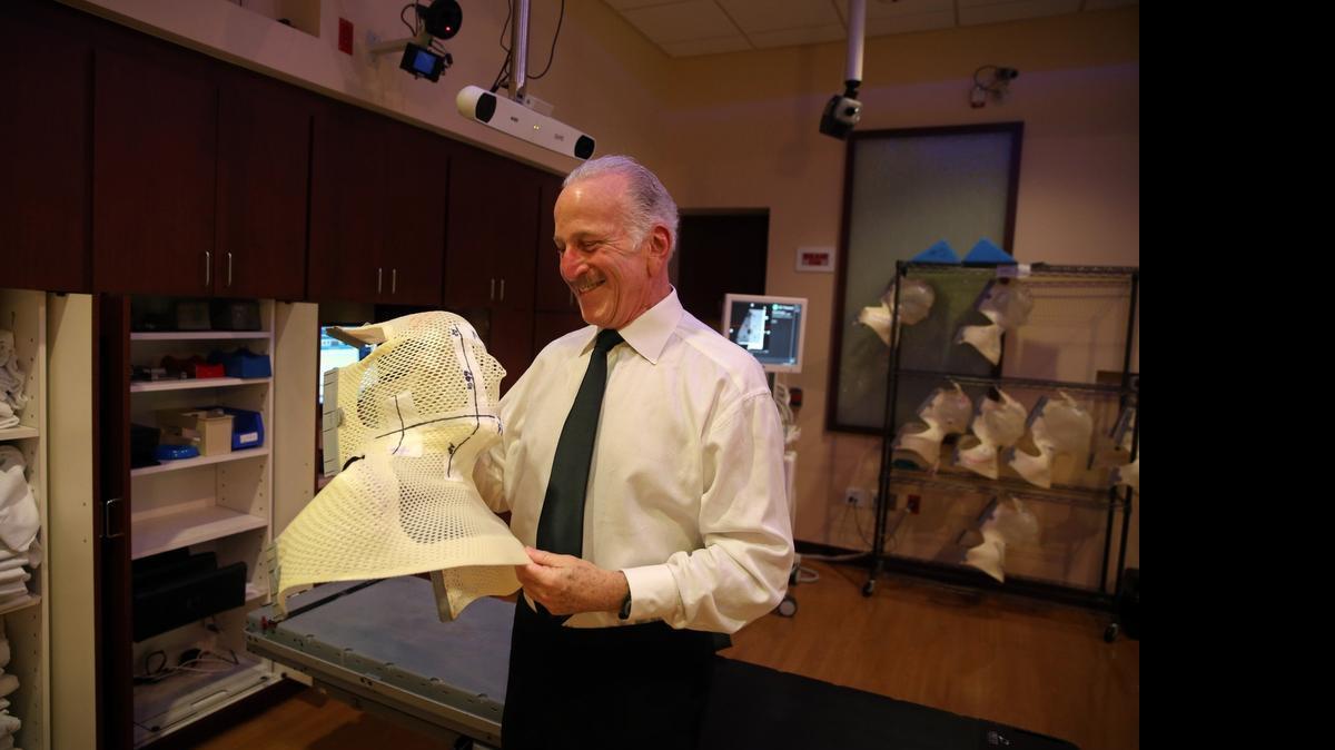 
After completing his final radiation treatment for tonsil cancer at the radiation oncology section of the University of Miami’s Sylvester Cancer Center, Miami-Dade Judge Stan Blake wore a tux to the event and looks at the "Aquaplast" that is used to stablize his head during the procedure. 

