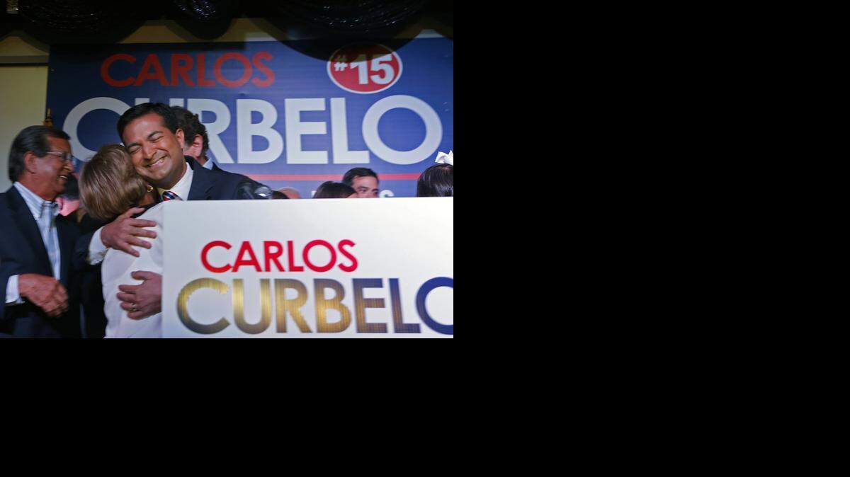 
Republican Carlos Curbelo hugs his mother, Teresita, after winning his election. He ousted Democratic Rep. Joe Garcia.

