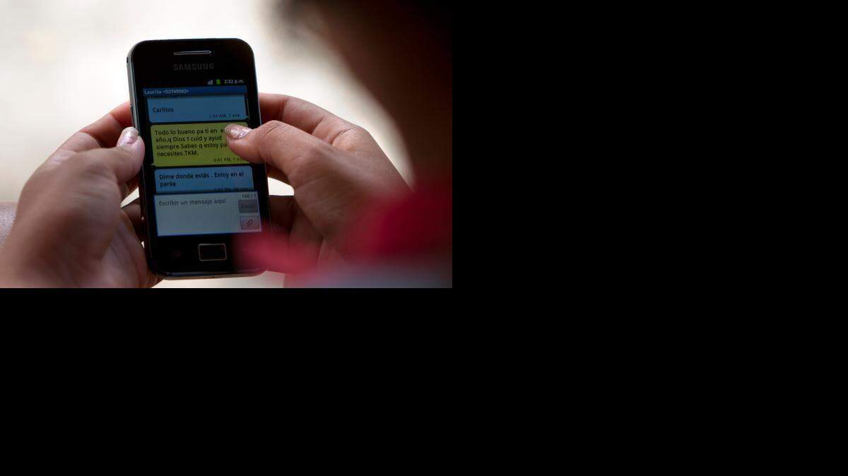 
Risky: A woman uses her cellphone in Camajuani, Cuba, as part of ‘Cuban Twitter,’ a communications network designed to undermine the government.
