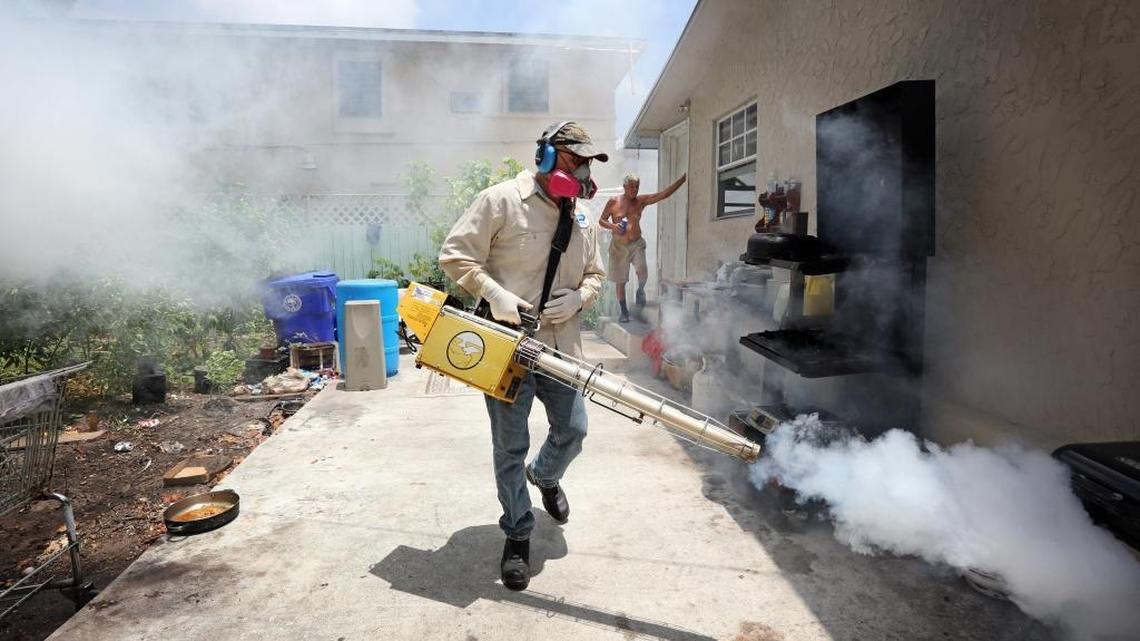 Carlos Varas, a Miami-Dade County mosquito inspector, uses a Golden Eagle machine to spray around a home in the Wynwood area of Miami on August 2, 2016.