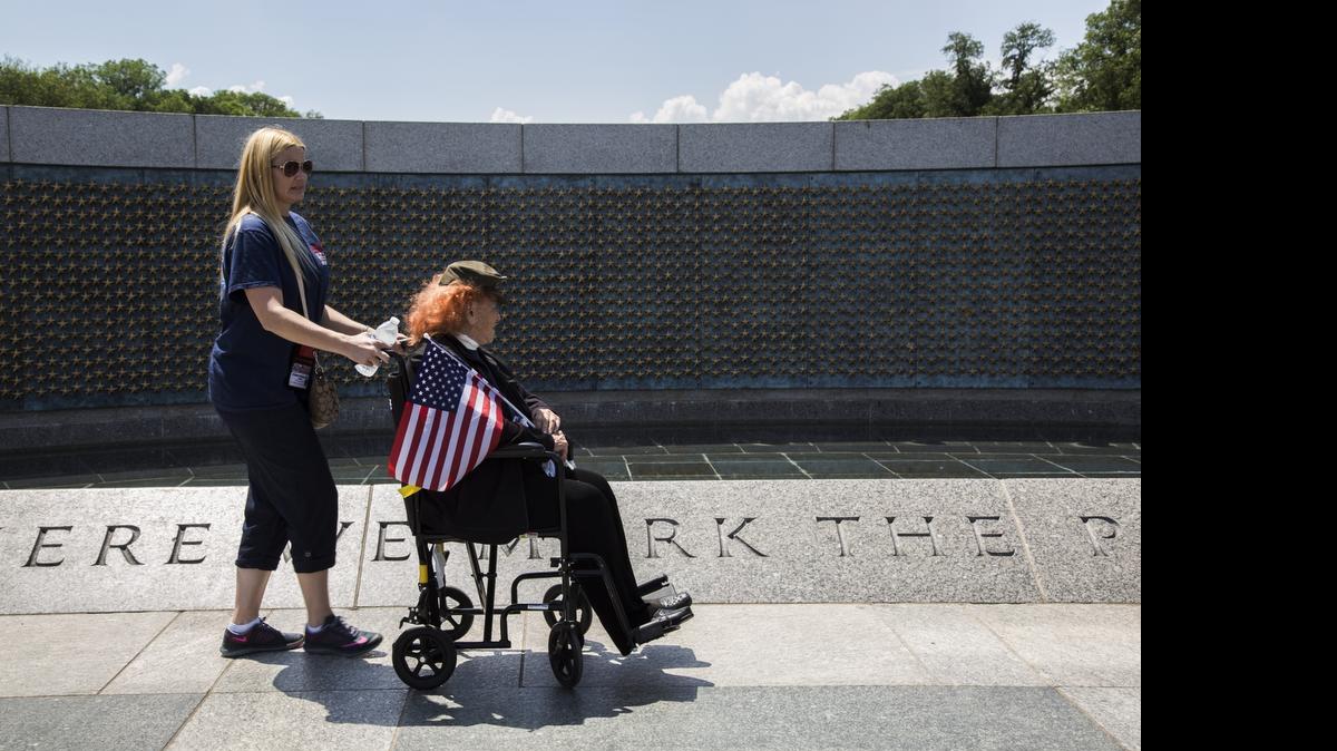 
Marine Corps / Air Corps veteran Conni Gordon, of Miami, is accompanied through the National World War II Memorial Saturday, May 30, 2015, in Washington. South Florida veterans toured Washington memorials as part of the the first Honor Flight to depart from Miami. Honor Flight is a national nonprofit that sponsors free visits to Washington war memorials for aging veterans.
