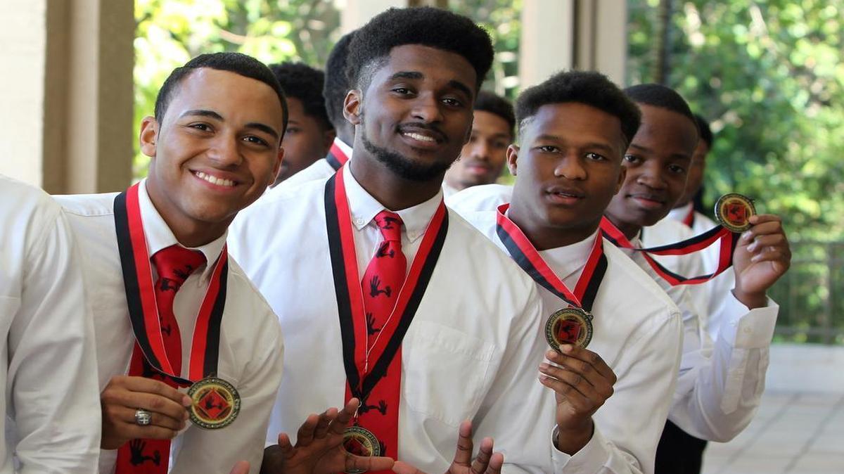 Miami-Dade high school students, from left, Jesus Marel, Bryan Adames, Widelair Varisse, and Christopher Alcius display their scholar medals at the 5000 Role Models of Excellence scholarship breakfast on Monday.