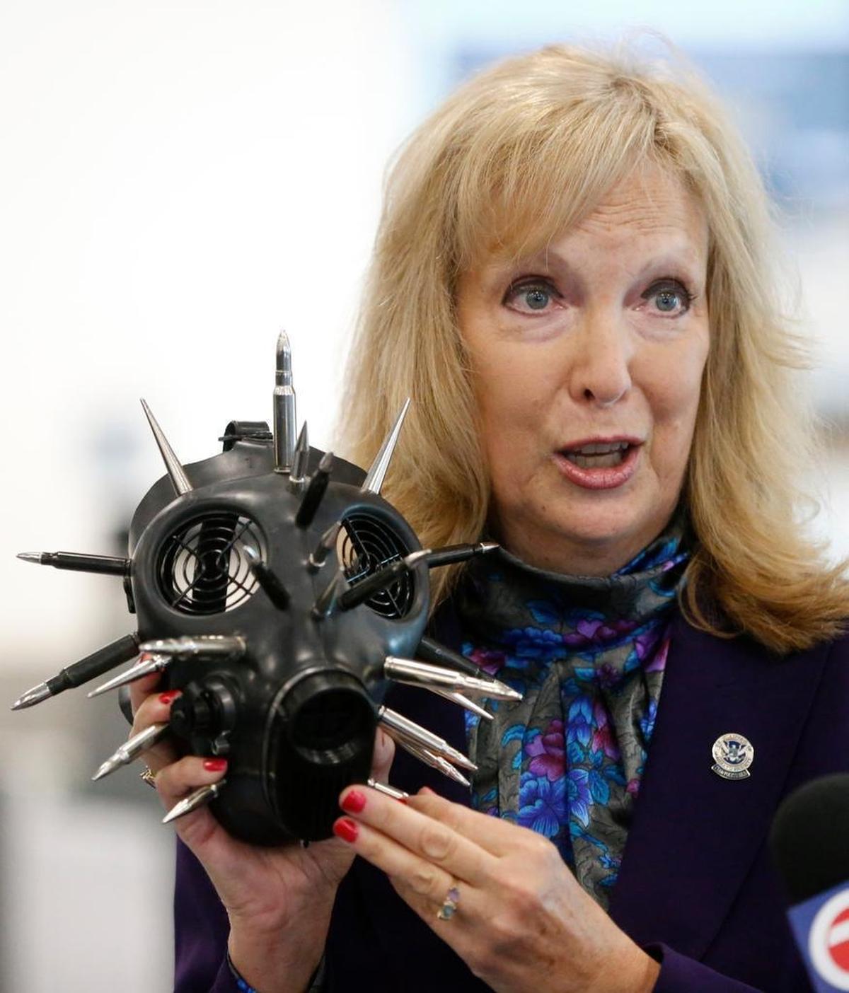 TSA Public Affairs Manager Sari Koshetz holds up a gas mask embellished with fake bullets that was found in a passenger's carry-on luggage recently at Miami International Airport.