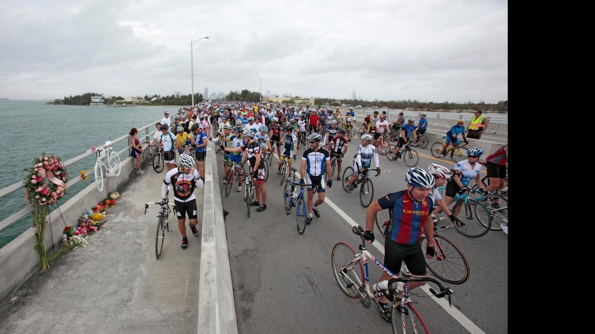 
Hundreds of bicyclists pass by a makeshift memorial and a place where cyclist Christopher LeCanne was killed by a drunk driver on Rickenbacker Causeway, during the Key Biscayne Memorial Ride in January 2010.

