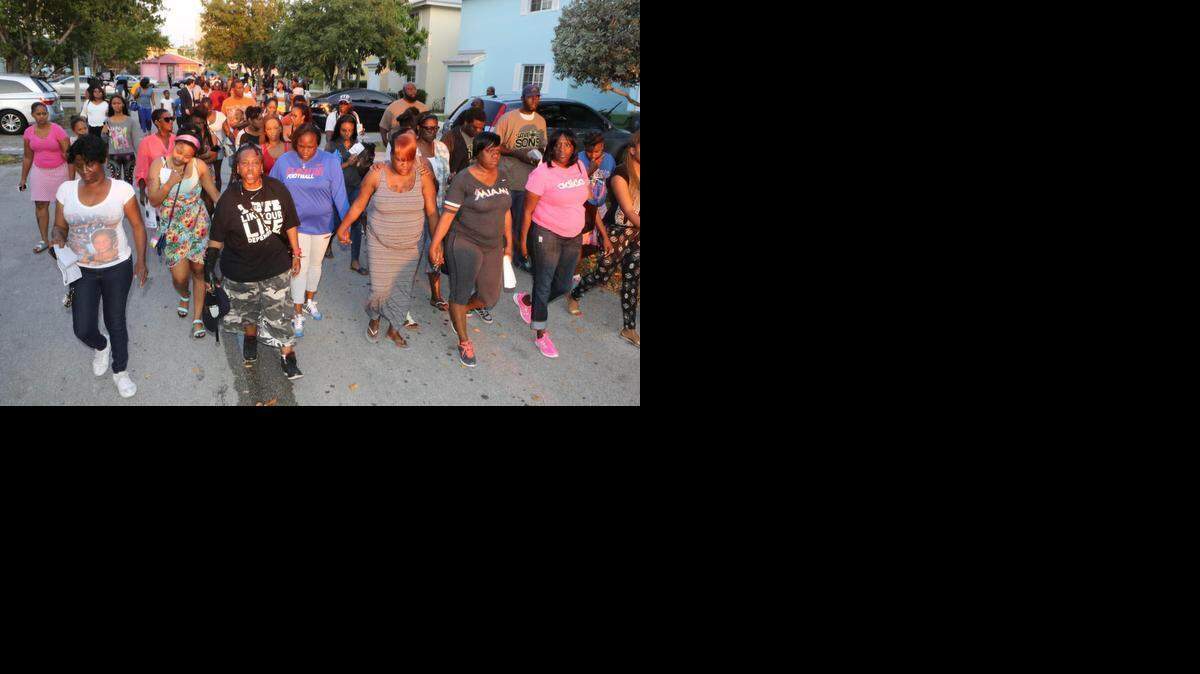 
IN OVERTOWN: Community members went door to door handing out to residents fliers about kids that were shot recently. 


