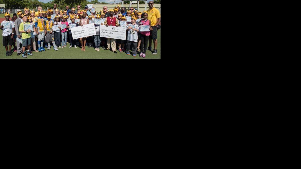 
Miami-Dade County Mayor Carlos A. Gimenez congratulated Pop Warner Scholar Achievers (cheerleaders and football players) from the Greater Miami South Florida Pop Warner League during a ceremony with GMSFPW President Craig McQueen and reps at halftime of the Sean Taylor Classic at North Miami Athletic Stadium.
