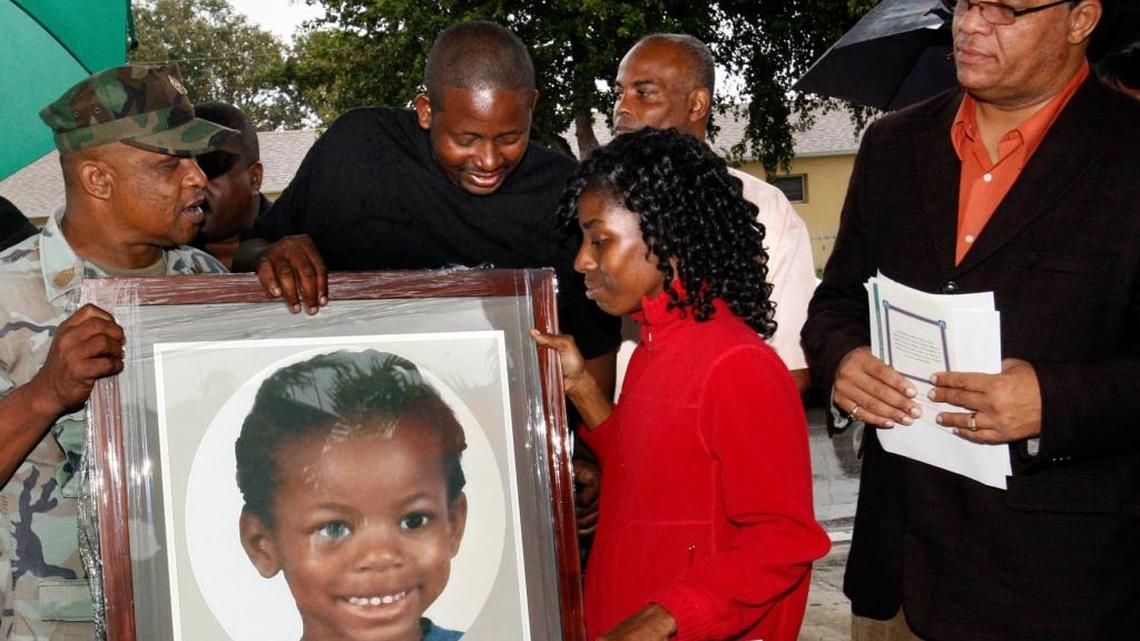 David and Sherrone Jenkins, center, Sherdavia Jenkins’s parents, look at a photograph of their daughter during a ceremony renaming a Miami park the Sherdavia Jenkins Peace Park. At left is family friend Tyrone Lamar. At right is Miami City Commissioner Richard P. Dunn II, who read a proclamation in honor of Sherdavia. The 9-year-old girl was struck and killed by a bullet as she played outside her Liberty City home in July 2006. The park is at Dr. Martin Luther King Jr. Boulevard (Northwest 62nd Street) and Northwest 12th Avenue in Miami.