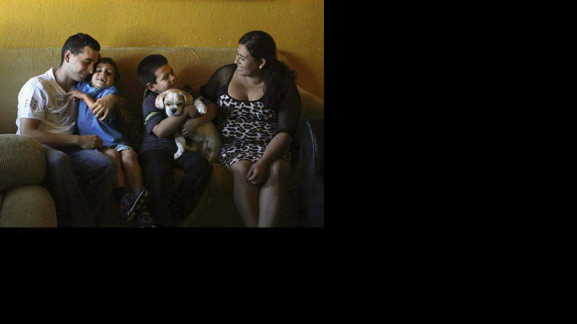 
GRATITUDE: Joel Diaz and Belkis Johana Mairena share happy moments with their sons Emanuel Diaz-Mairena, 6, left center, and Richard Diaz-Mairena, 8, who holds family dog, Jack, on Thursday, Oct. 30, 2014 in their rented home in Miami.
In July, Emanuel was hit by a car while playing ball in the street with Richard and friends. Emanuel suffered traumatic brain injury, was in a six-week coma, and had a seizure. He has recovered more than his doctors expected. The family is thankful to have their sons with them and for the doctors at Jackson Memorial Hospital.
