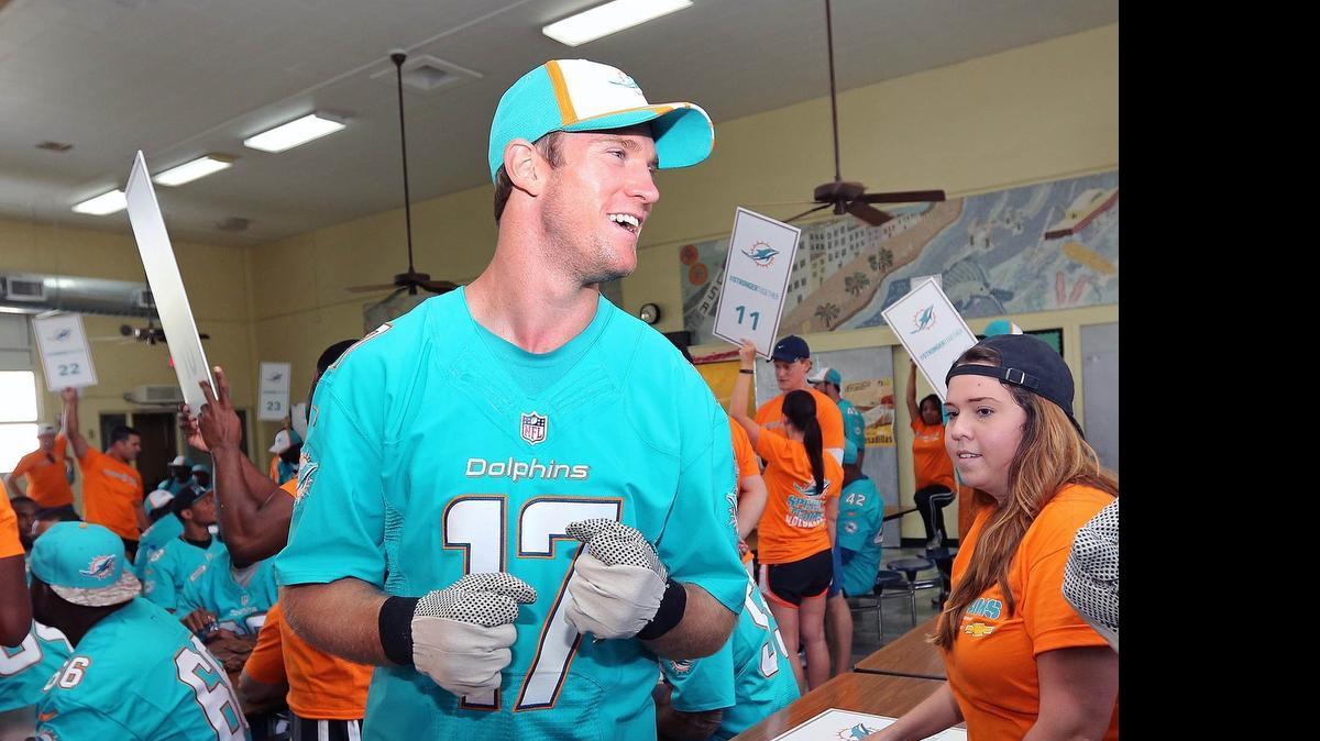 
Miami Dolphins quarterback Ryan Tannehill shares a laugh with his teammates in the auditorium of Mae Walters Elementary School in Hialeah.
