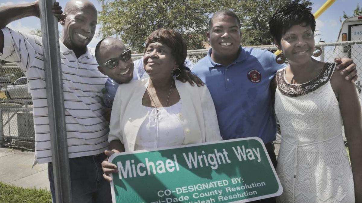 Daryl Wright, Derrick Wright, brothers of Michael Wright, his mother DeAlma Wright Andrews, his son Corey Wright and his sister Vicky Martin pose for pictures with a street sign of Michael Wright Way during a dedication ceremony in front of Hialeah Fire Station #6.