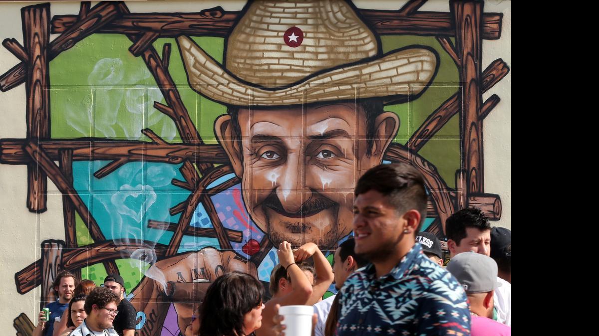 
Street party attendees gather by a mural titled "El Viandero" by artist donrimx in the new Leah Arts District in Hialeah at 1501 E. 10th Ave. on Sunday, May 17, 2015.
