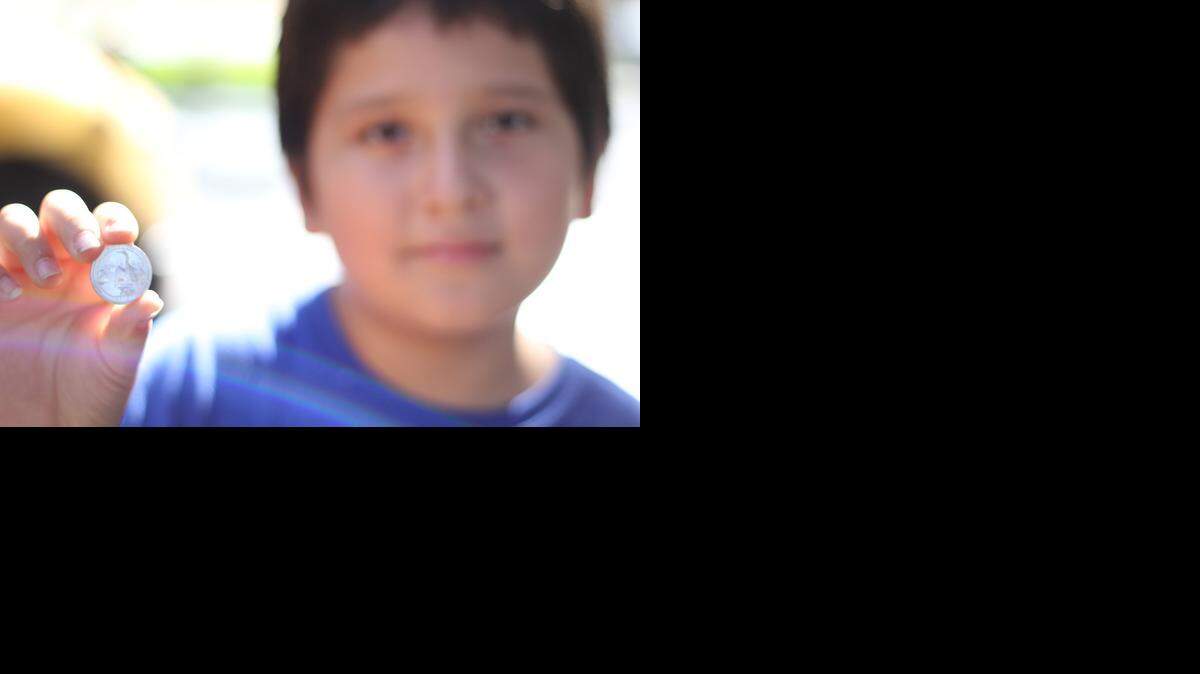 
Jonathan Patino, a fourth-grader at Leisure City K-8 Center holds the new Everglades National Park quarter. 
