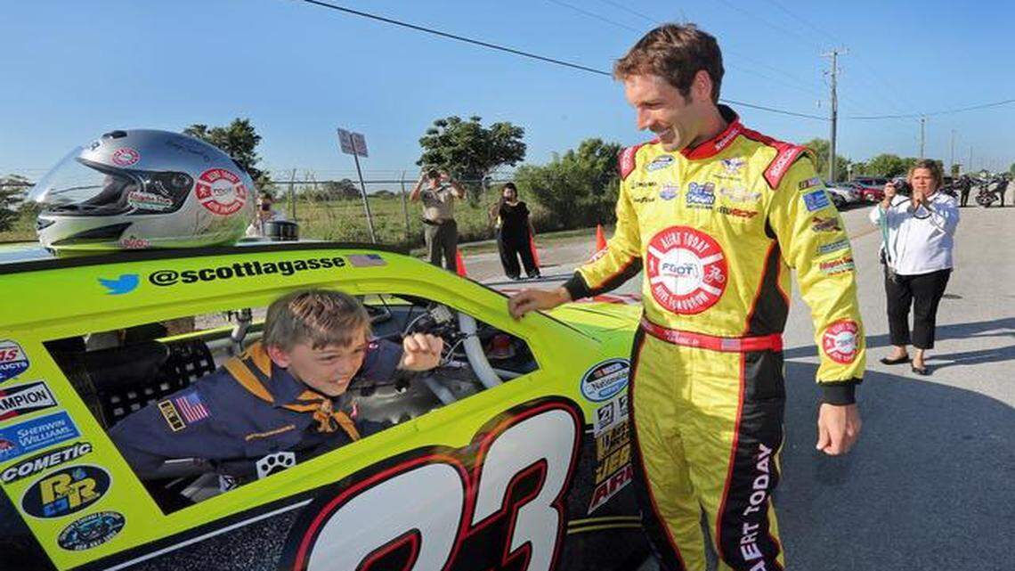 
Cub Scout and student Caleb Sowinski bails out of NASCAR Series Driver Scott Lagasse Jr. race car as part of NASCAR’s and Team/SLR’s Drive a Scout to School Program on Thursday Nov. 13, 2014.
