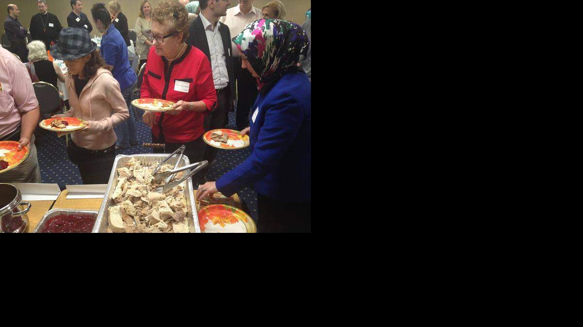 
Marifeli Perez-Stable, in the red jacket, and Ozlem Pala, in the blue jacket, serve themselves Thanksgiving fare during an interfaith Thanksgiving dinner hosted by the South Florida branch of the Atlantic Institute Sunday night at Florida International University. 
