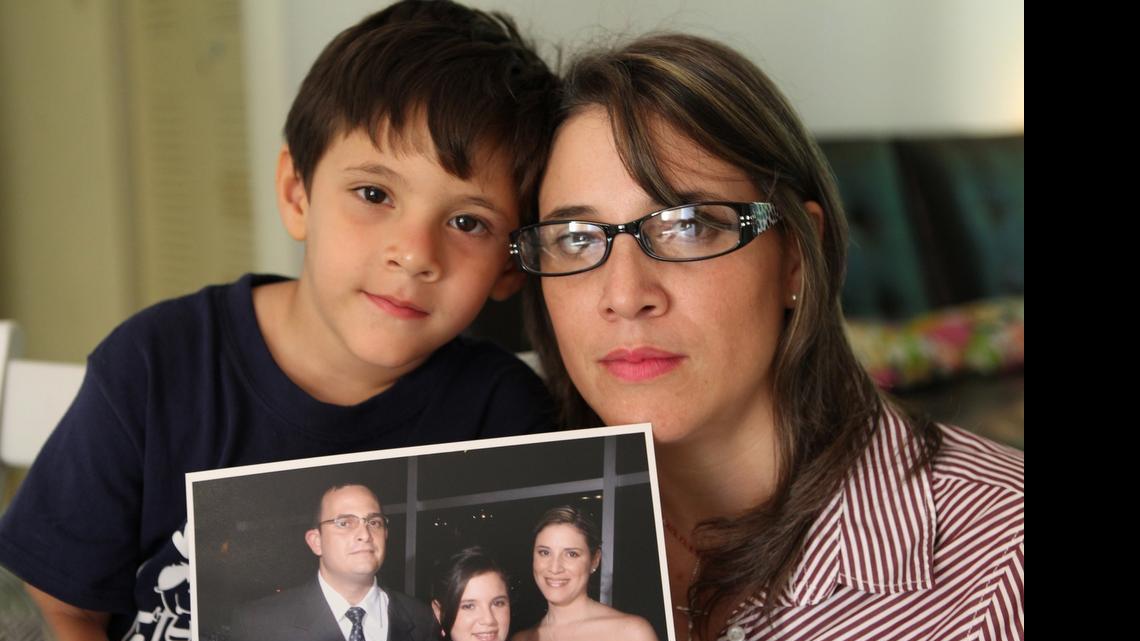 
Venezuelan journalist Alicia Faneite, who is seeking political asylum in the United States, with her son Mauricio Enrique González. They are holding a family photo showing husband Leonardo Gonzalez who is stuck in Venezuela.

