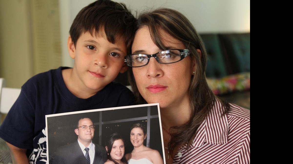 
Venezuelan journalist Alicia Faneite, who is seeking political asylum in the United States, with her son Mauricio Enrique González. They are holding a family photo showing husband Leonardo Gonzalez who is stuck in Venezuela.
