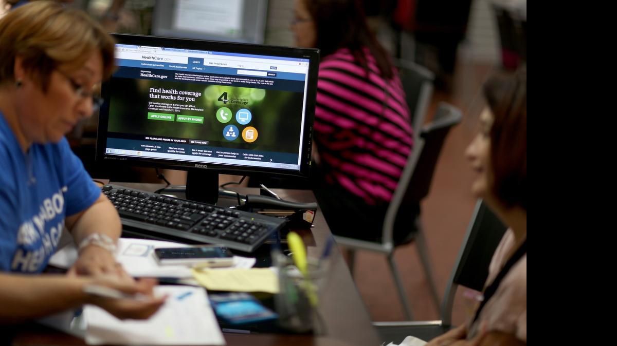 
Mercy Cabrera (L), an insurance agent with Sunshine Life and Health Advisors, helps Amparo Gonzalez purchase an insurance policy under the Affordable Care Act at the store setup in the Westland Mall on Nov. 14, 2013, in Hialeah.
