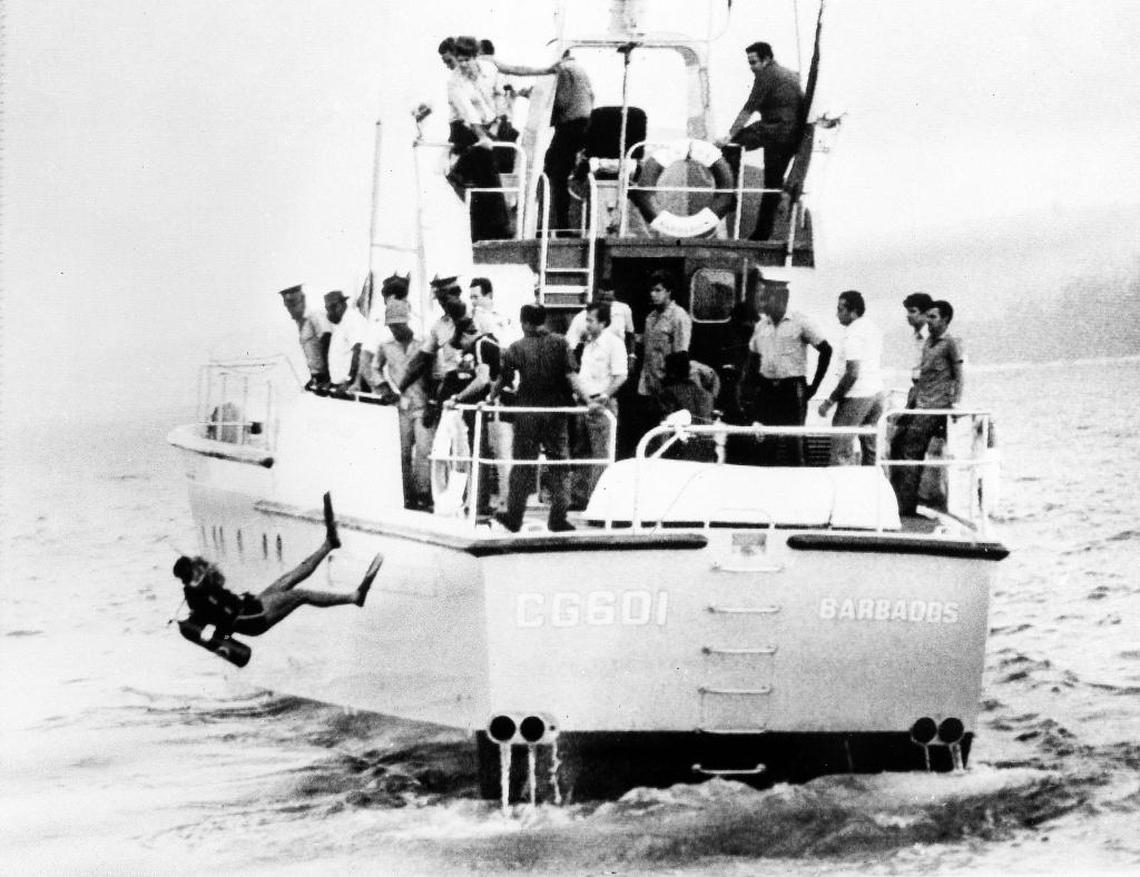 A member of a Cuban aviation specialist team dives off a Barbados Coast Guard boat, Oct. 7, 1976, looking for the remains of a Cubana Airlines plane that crashed into the Caribbean Sea after an on-board explosion, killing all 73 people aboard the DC-8 bound for Jamaica and Cuba.