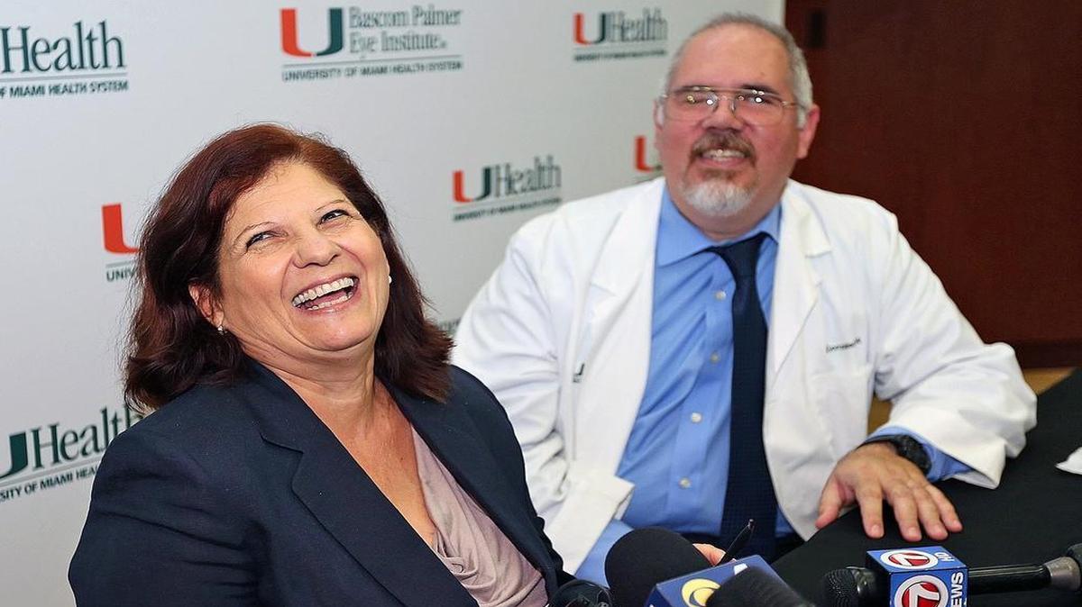 
Carmen Torres from Tampa is the first blind woman to receive the bionic eye implant system in Florida as she smiles at a press conference on July 31, 2015, next to Alex Gonzalez, right, a biomedical engineer at the University of Miami's Bascom Palmer Eye Institute. 
