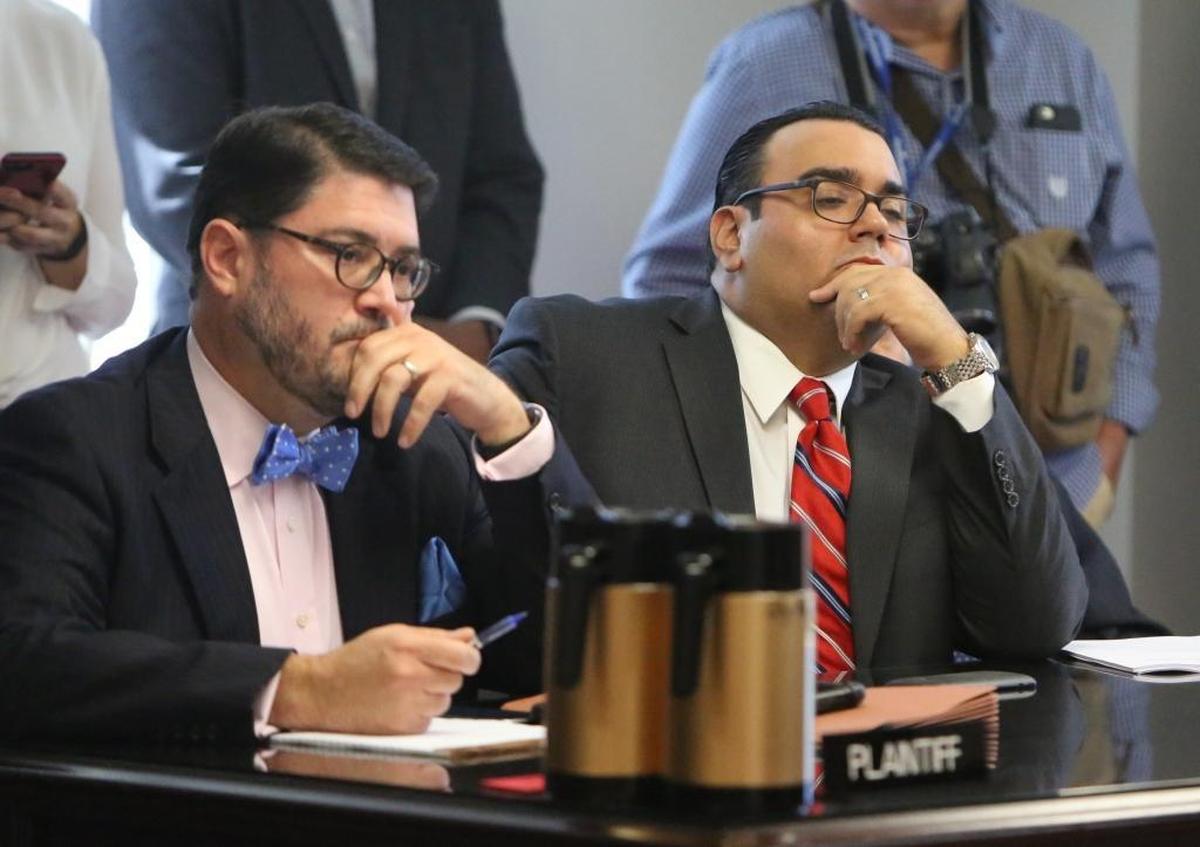 Attorney J.C. Planas, left, and Alfie Leon listen as Judge Thomas Rebull issues his ruling upholding the election of Joe Carollo to the District 3 Miami City Commission seat. Leon, the losing candidate, challenged Carollo’s residency in the district.