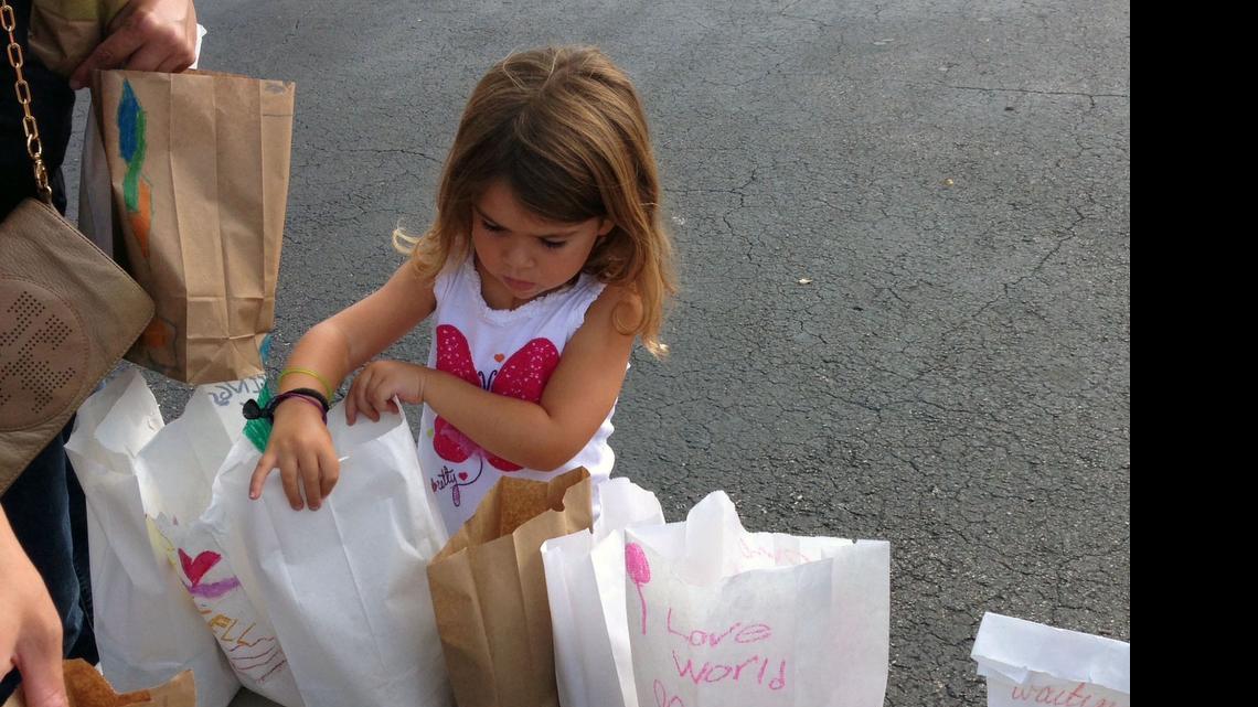 
Daniela Perez, 5, is checking each #teachHope70x7 bag for a sandwich, chips and a snack before they are packed into the cars to go to the streets of downtown Miami. 
