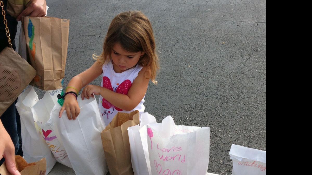 
Daniela Perez, 5, is checking each #teachHope70x7 bag for a sandwich, chips and a snack before they are packed into the cars to go to the streets of downtown Miami. 
