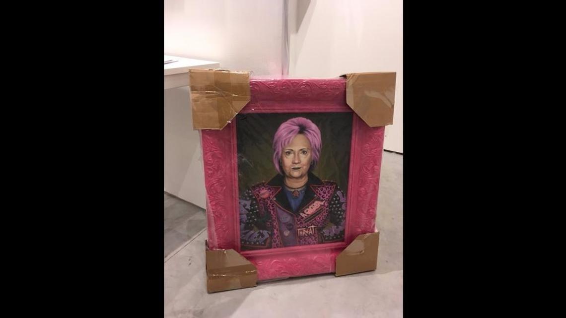 Fair director Nick Korniloff said two security dogs reacted to a crate containing a painting of Hillary Clinton — pictured in a shaggy pink hairdo — during a pre-show security sweep.