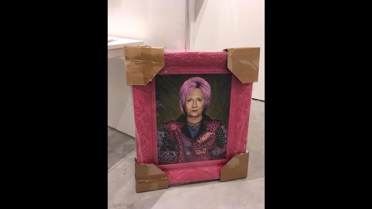 Fair director Nick Korniloff said two security dogs reacted to a crate containing a painting of Hillary Clinton — pictured in a shaggy pink hairdo — during a pre-show security sweep.