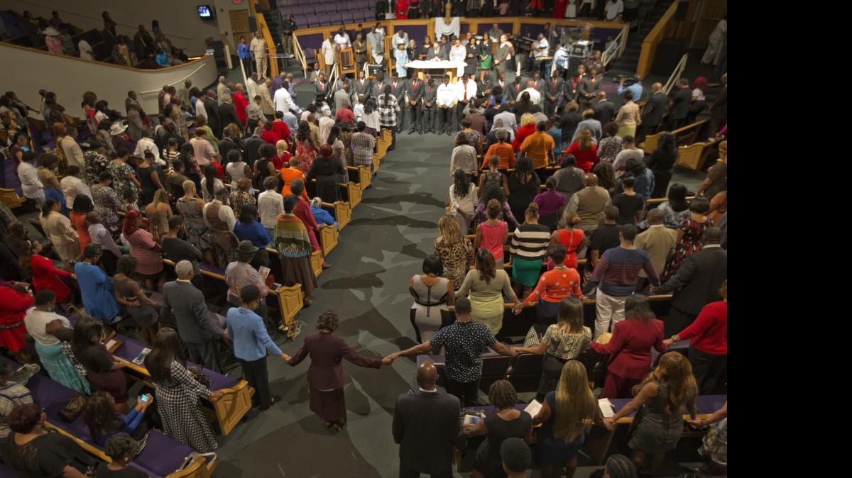 
The congregation of New Birth Baptist Church in Miami holds hands and gets emotional as Bishop Victor T. Curry prays Sunday, June 21, 2015, for the families of the victims of the tragic church shootings in Charleston, S.C.
