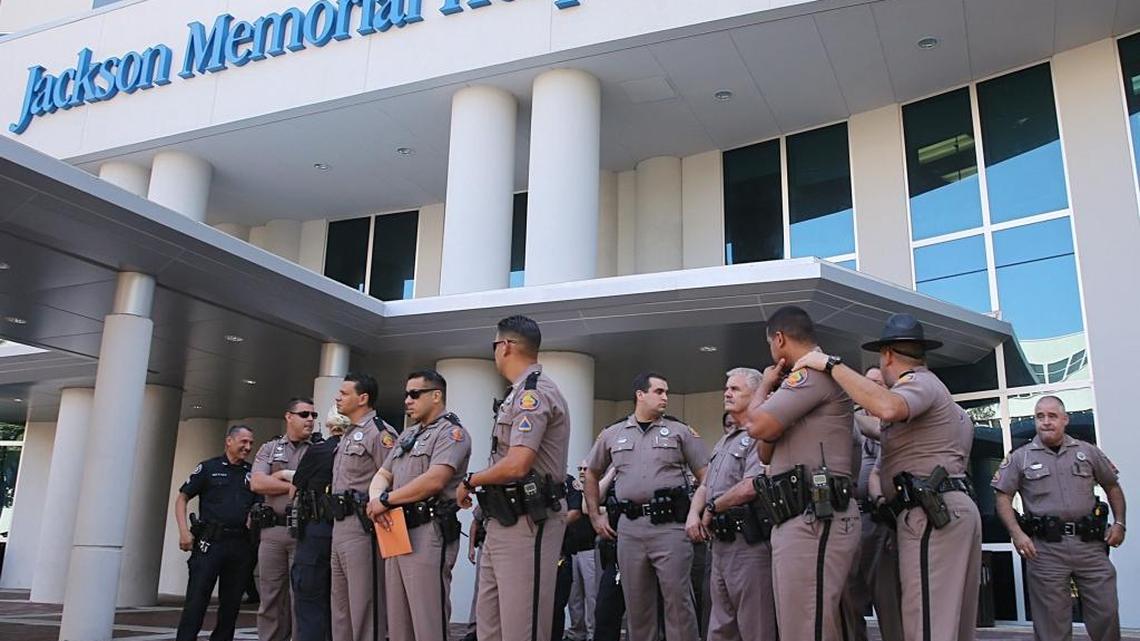 A group of Florida Highway Patrol officers gathered outside the Jackson Memorial Hospital Ryder Trauma Center as their colleague, Trooper Carlos Rosario, a 12-year veteran of the force, was been treated after he was nearly killed Friday when a car struck him around 9:30 a.m. Friday, March 17, 2017, on the Dolphin Expressway in Miami. FHP said Saturday that Rosario was ‘stable but still critical’ after emergency surgery for multiple injuries.