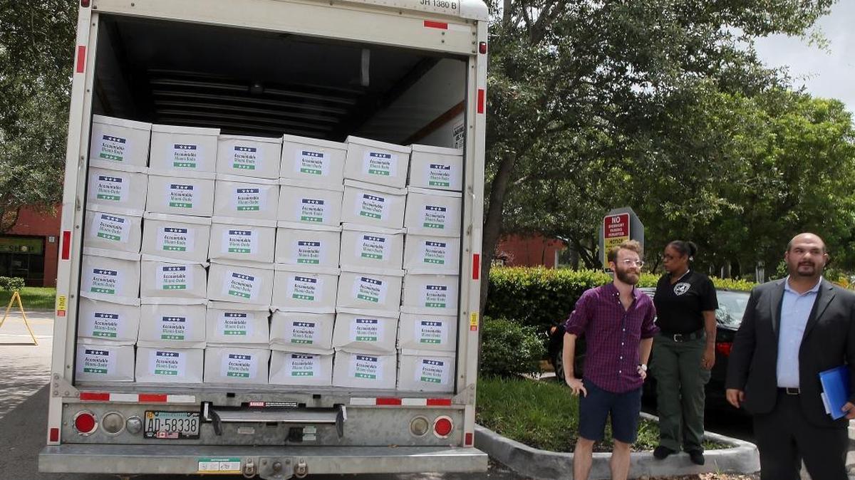 Christian Ulvert (far right) and a group of activists from An Accountable Miami-Dade gathered in front of the Miami Dade County Election Department headquarters in Doral on Tuesday August 2, 2016, to deliver two truck loads of petitions asking that new restrictions for campaign donations be placed on the November ballot.