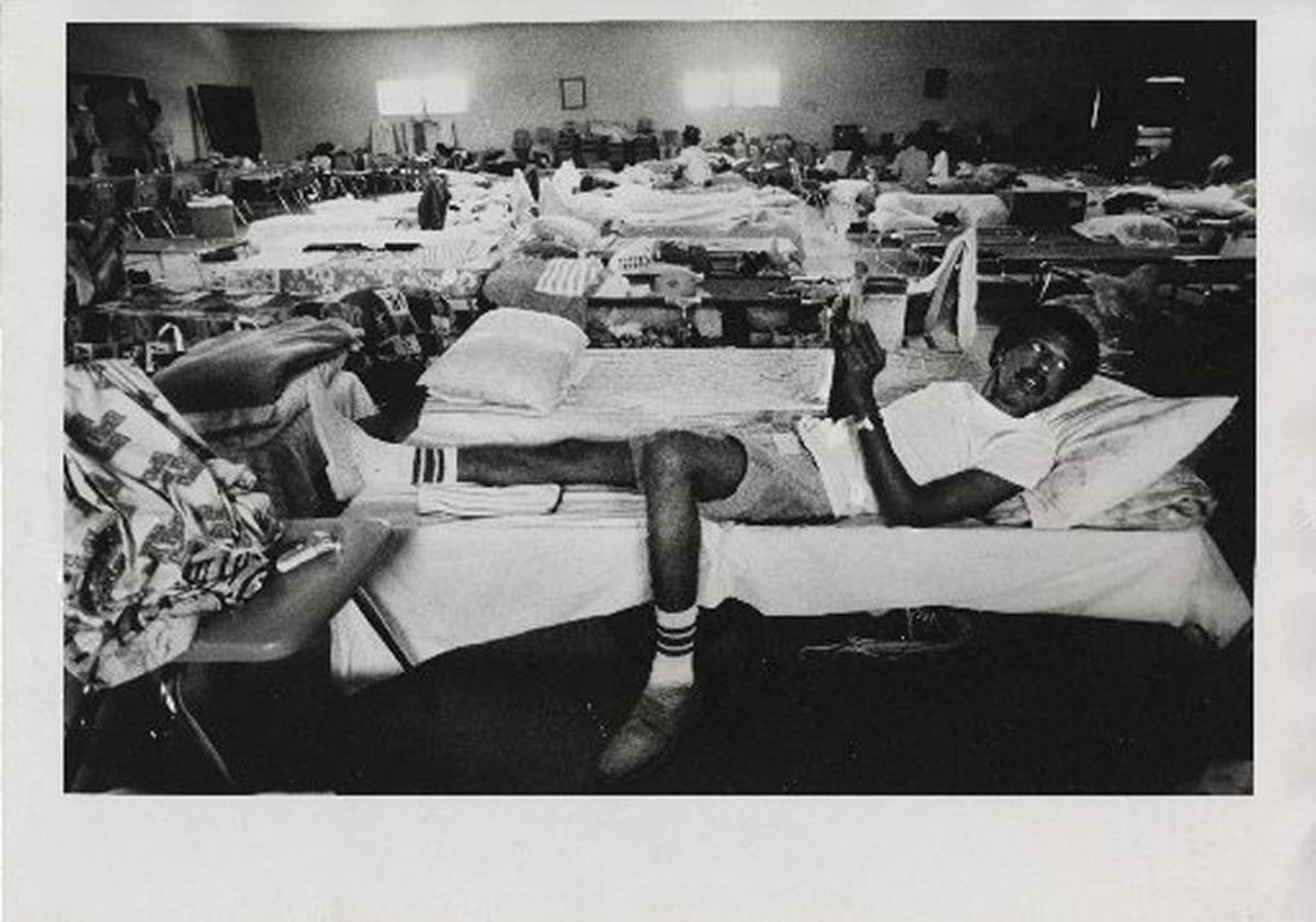 In this 1980 photo, Lazaro Gutierrez, who arrived on the Mariel boatlift, learns English from his English/Spanish dictionary while resting on his cot in Miami’s St. Agatha Catholic Church and prepares to look for a job.