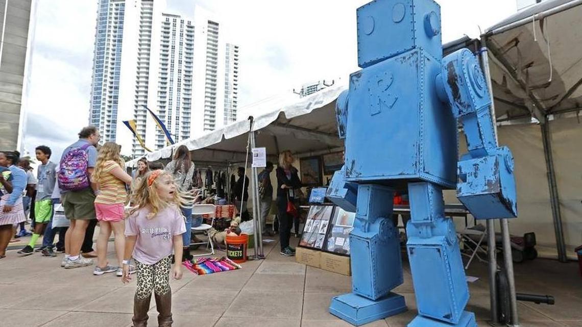Abbey Rose McDonald, 6, jumps next to a tall blue robot on display during the Miami Mini Maker Faire at YoungArts Plaza last year. AL DIAZ adiaz@miamiherald.com