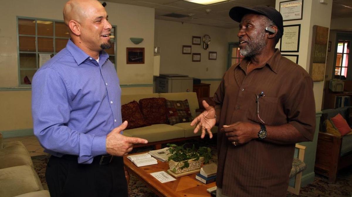 Stephen Alvarez, left, executive director of New Hope Corps rehabilitation center, talks with Herbert Jackson, intake supervisor, at the center’s Homestead facility.