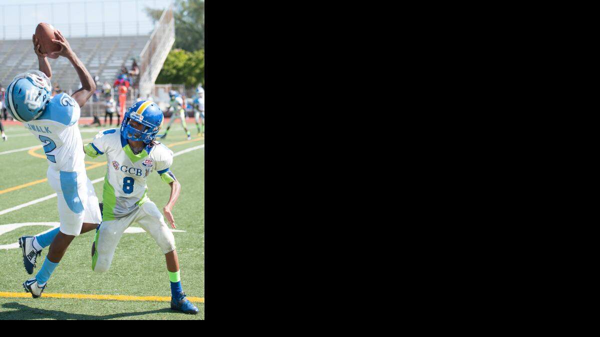 
Jaiden Francois (2) of the Florida City Razorbacks makes an amazing catch against Curvontae Ducksworth (8) and the Gwen Cherry Bulls during the Greater Miami South Florida Pop Warner Pee Wee Division I Super Bowl of the Sean Taylor Classic at North Miami Athletic Stadium. 
