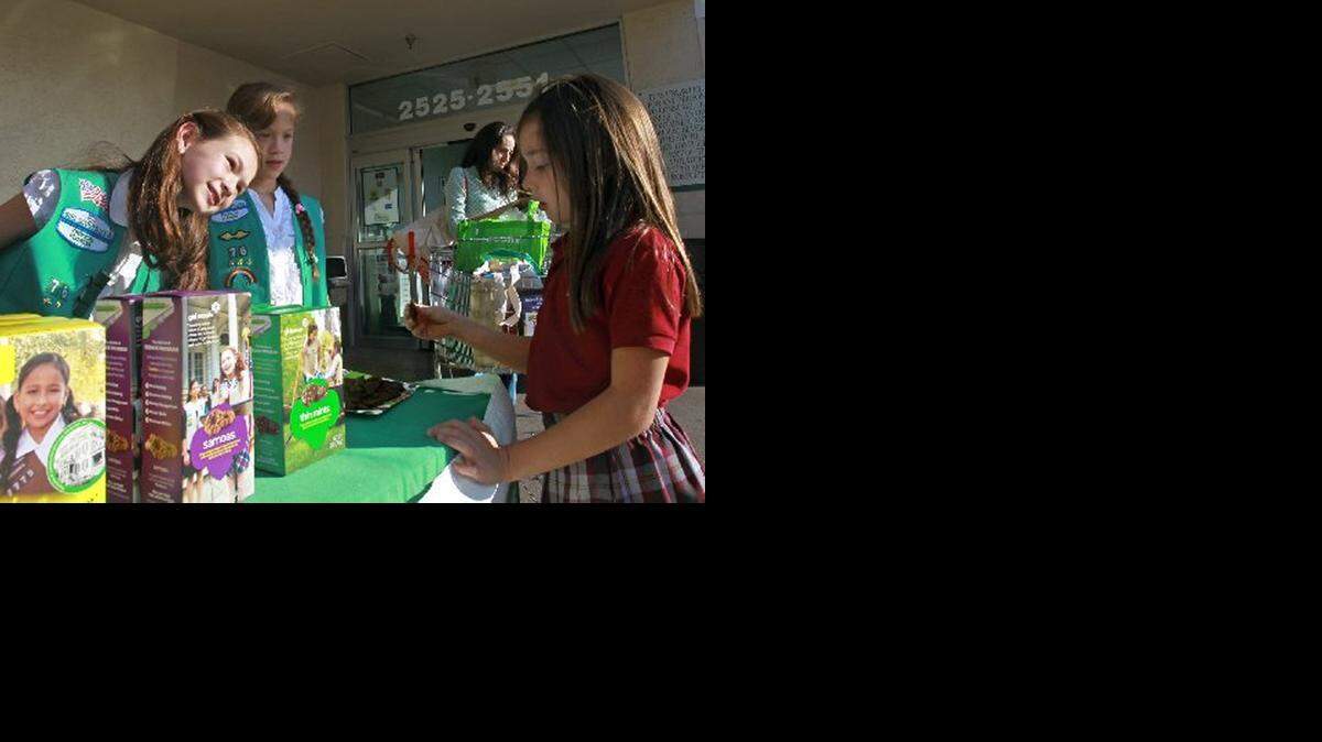 
Junior Girl Scout Samantha Salstein, 10, left, smiles at potential customer Sophia Juhasz, 7, right, sampling a Thin Mint cookie Thursday, Jan. 24, 2013. Girl Scout cookie sales are set to begin this month in South Florida.
