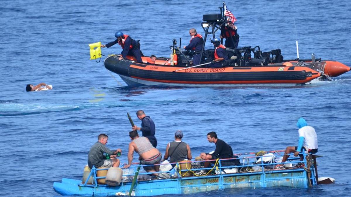 
A crew member  passes a life jacket to a Cuban who jumped off his vessel near Key West 
