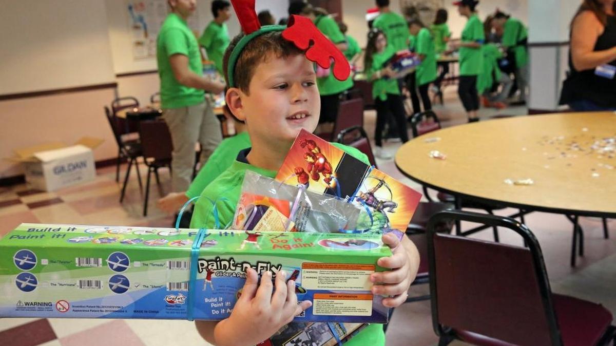 Jake Stewart, 8, carries an armful of gifts for children spending Christmas at the Salvation Army in Miami. Jake and his family provided all the toys and other gifts for the families at the shelter. The Stewarts were part of a team of volunteers from the Greater Miami Jewish Federation who spent the Christmas holiday preparing food, sharing gifts, and socializing with residents of the Salvation Army shelter in Miami.