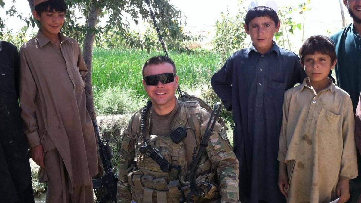 Capt. Michael Shepherd (center) poses with Afghan residents while serving with the U. S. Army in 2013.