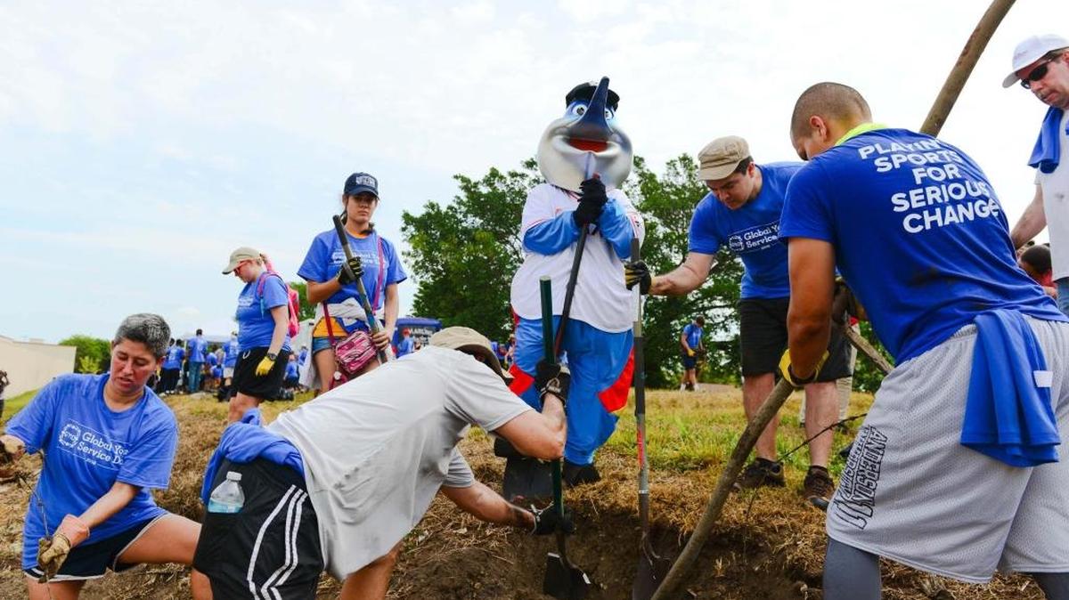 From left, Ivis Balseiro, Ian McGregor, Palmer Trinity Senior Catherine Dos Santos, 18, Miami Marlins Mascot Billy the Marlin, Bruno Feijoo, and Thomas Padro help dig a tire out of Ludlam Trail on Global Youth Service Day Saturday, April 16, during an effort to clean up the trail alongside friends of Ludlam Trail, HandsOn Miami, and Marlins Ayudan.